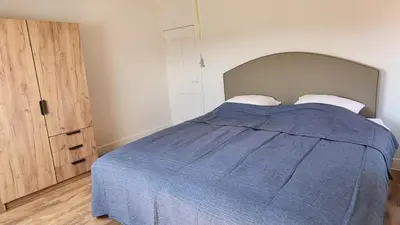 a bedroom with a bed with a blue blanket at Boshovense Velden in Grobbendonk