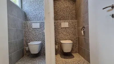 a bathroom with two toilets and a shower at Boshovense Velden in Grobbendonk