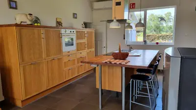a kitchen with wooden cabinets and a wooden table at Boshovense Velden in Grobbendonk