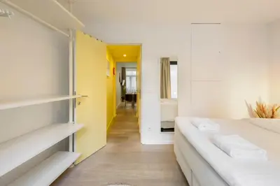 a bedroom with two beds and a yellow wall at R73 Apartments by Domani Hotels in Antwerp