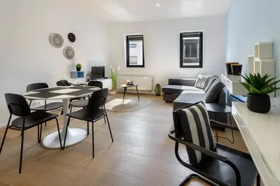 a living room with a table and chairs and a couch at R73 Apartments by Domani Hotels in Antwerp