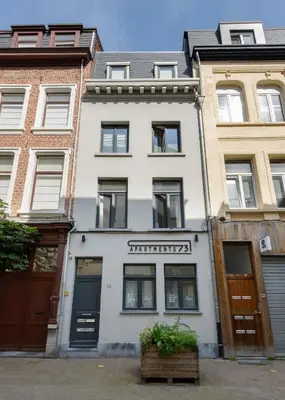 a white building with a sign on it at R73 Apartments by Domani Hotels in Antwerp