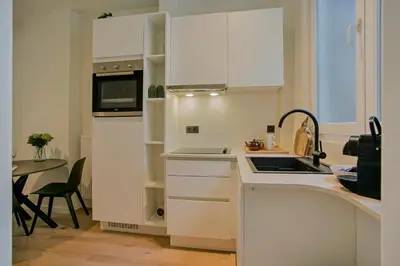 a white kitchen with a sink and a microwave at New renovated condo's @ trendy south in Antwerp
