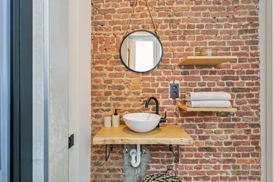 a bathroom with a sink and a brick wall at New renovated condo's @ trendy south in Antwerp