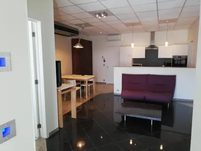 a living room with a couch and a kitchen at Nuvola ULTIMO Resort in Zottegem
