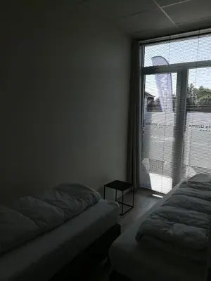 a bedroom with two beds and a large window at Nuvola ULTIMO Resort in Zottegem