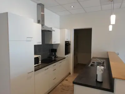 a kitchen with white cabinets and a black counter top at Nuvola ULTIMO Resort in Zottegem