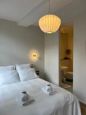 a bedroom with a white bed with towels on it at La Senne in Brussels