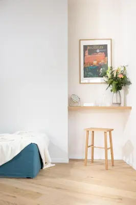 a bedroom with a bed and a wooden stool at La Senne in Brussels