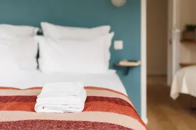 a bedroom with a bed with white towels on it at La Senne in Brussels