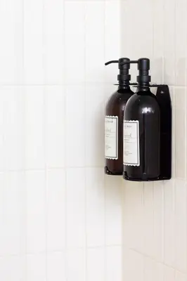 two bottles of soap are hanging on a wall at La Senne in Brussels