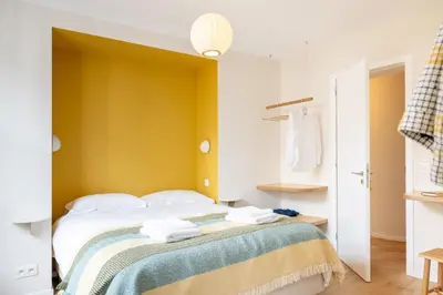 a bedroom with a bed with a yellow wall at La Senne in Brussels