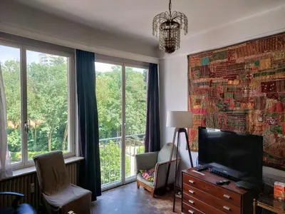 a living room with a tv and a large window at ImpactHorizon in Brussels