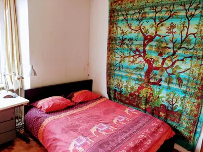 a bedroom with a bed with a tapestry on the wall at ImpactHorizon in Brussels