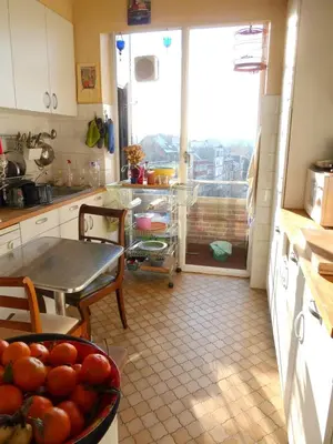 a kitchen with a table and a bowl of fruit on a table at ImpactHorizon in Brussels