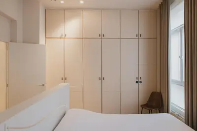 a bedroom with white cabinets and a bed at Blue Bird Residence in Antwerp