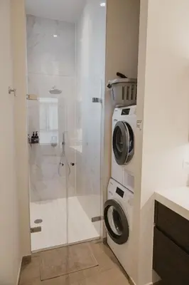 a bathroom with a shower and a washing machine at Blue Bird Residence in Antwerp