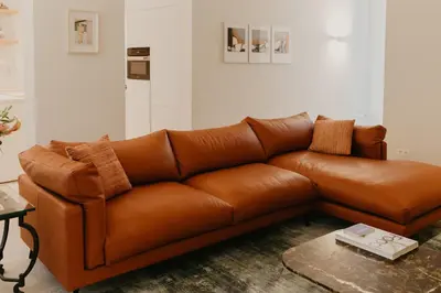 a brown leather couch in a living room at Blue Bird Residence in Antwerp
