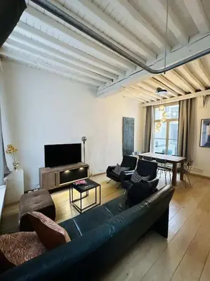 a living room with a couch and a table at Charmante woning in city center in Antwerp