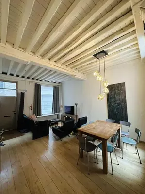 a living room with a wooden table and chairs at Charmante woning in city center in Antwerp