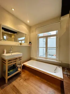 a bathroom with a tub and a sink and a window at Charmante woning in city center in Antwerp