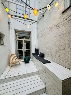 a patio with a bench and a brick wall at Charmante woning in city center in Antwerp