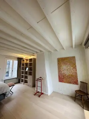 a room with a bed and a painting on the wall at Charmante woning in city center in Antwerp