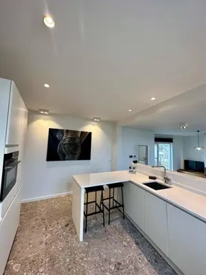 a large white kitchen with a counter and a sink at Sunny apartment @theater area in Antwerp