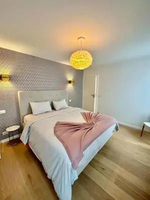 a bedroom with a large bed and a yellow light at Sunny apartment @theater area in Antwerp