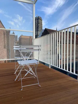 a white chair sitting on a deck on a balcony at #2800ourhome 301 in Mechelen
