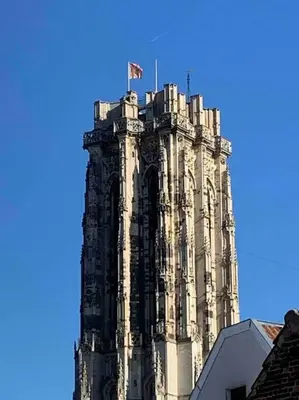 a tall tower with a flag on top of it at #2800ourhome 201 in Mechelen
