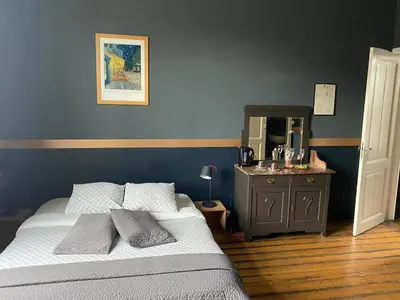 a bedroom with a bed and a dresser with a mirror at Vakantielogies Faja lobi in Ghent