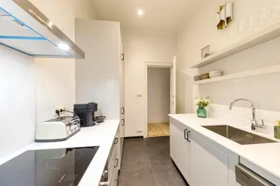 a kitchen with white counter tops and a sink at Appartement dans l'hypercentre in Brussels