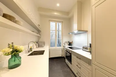 a kitchen with white counters and a vase of flowers at Appartement dans l'hypercentre in Brussels