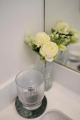 a vase of flowers on a counter in front of a mirror at Appartement dans l'hypercentre in Brussels