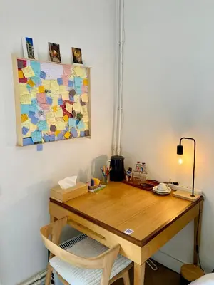 a wooden desk with a chair and a painting on the wall at Calm, green & birdsong in Brussels