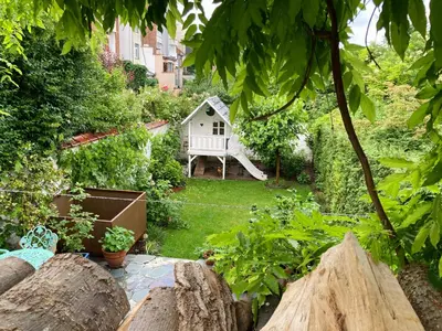 a backyard with a small white house in the yard at Calm, green & birdsong in Brussels