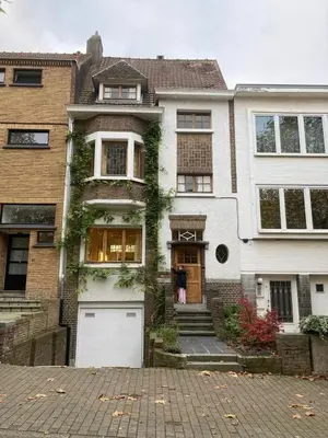 a house with a white garage in front of it at Calm, green & birdsong in Brussels