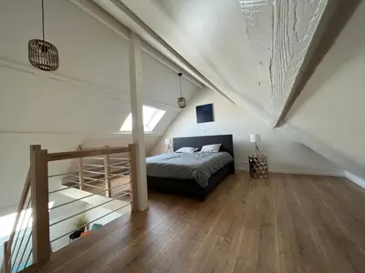 a bedroom with a bed and a staircase in a attic at Cosy Nest in Brussels