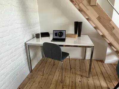 a desk with a laptop and a chair in a room at Cosy Nest in Brussels