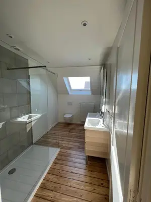 a bathroom with two sinks and a toilet at Cosy Nest in Brussels