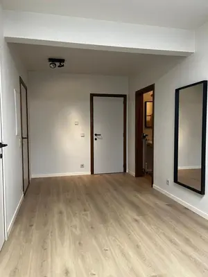 an empty room with two doors and wooden floors at Budget Flex in Geel