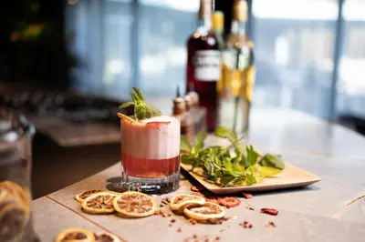 a drink sitting on top of a table with food at voco Brussels City North by IHG in Vilvoorde