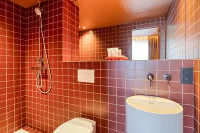 a bathroom with a toilet and a sink and a shower at Maison Arya in Brussels