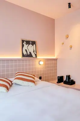 a bedroom with a white bed with brown and white pillows at Maison Arya in Brussels