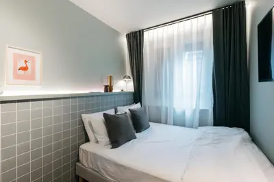 a small bedroom with a bed with a window at Maison Arya in Brussels