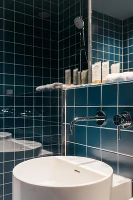 a bathroom with a sink and a blue tiled wall at Maison Arya in Brussels