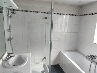 a bathroom with a shower and a sink and a tub at bel etage woning in Ghent
