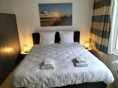 a bedroom with a white bed with towels on it at bel etage woning in Ghent