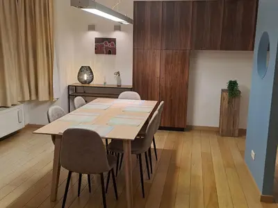 a dining room with a wooden table and chairs at bel etage woning in Ghent